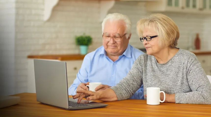 Senior couple researching financial assistance programs on a laptop