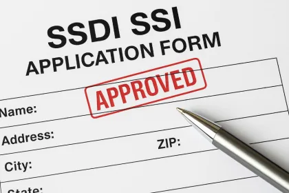Close-up of a disability benefits application form marked “Approved” for SSDI/SSI financial aid in 2025